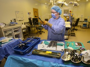 Scrub nurse Stephanie Williams prepares surgical instruments in an operating room at Belleville General Hospital in 2014. Quinte Health Care has again increased the amount of operations being performed as part of an ongoing plan to return to pre-pandemic levels.