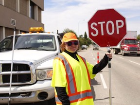 Flag person Jasmine Mutch-Sloat directs traffic at the intersection of 100 St. 108 Avenue across from KFC Plaza as construction continues throughout certain areas of the city on Monday June 12, 2017 in Grande Prairie, Alta.