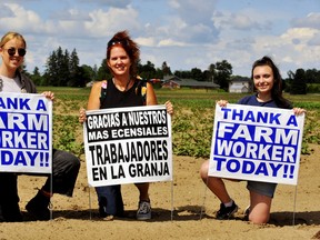 A local group calling itself the Norfolk Community Alliance Against Racism has been placing signs around the county in recent days thanking migrant farm workers for the contribution they make to local prosperity. They also plan a rally at Governor Simcoe Square Friday followed by a solidarity march through Simcoe. Members include, from left, Payton Rose Mitchell, of Hagersville, Leanne Arnal of Waterford, and Imogene Stortini of Simcoe. – Monte Sonnenberg photo
