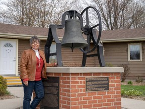 Shannon Prince, curator at the Buxton National Historic Site and Museum, stands by the Liberty Bell in early May. The bell, donated in 1850, was rung to herald the arrival of new refugees to the historic Black settlement. Max Martin/Postmedia Network