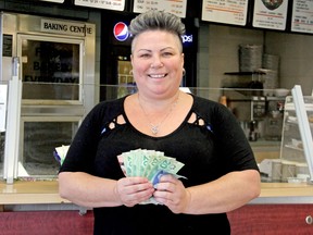 Lucie St John holds $175 donated Friday to Outloud North Bay at     Between The Bun. 
Mackenzie Casalino Photo