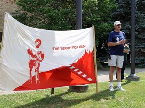 John Versaevel, the chair of the Woodstock Terry Fox Run, speaks to a crowd of people after raising the Terry Fox flag at Museum Square Wednesday July 15, 2020.