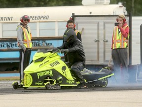 Race volunteers gaze at the modified snowmobile of Sexsmith resident Shannon Franke during the North Peace Bracket Racing Association event at the Beaverlodge Airport on Sunday morning.  Rain halted the event late on Sunday morning, with final results not posted as of press time. Prior to the rain, Franke was perfect winning both of his heats. The association will host another event this coming weekend at the airport, located south of Beaverlodge.