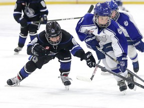 Mathieu Berthiaume  of the Nickel City Jr. Sons trips up Dawson Morris of the Sudbury Wolves during minor atom AA action from the opening day of the Sudbury Regional Silver Stick hockey tournament in Sudbury, Ont. on Thursday, November 30, 2017.
