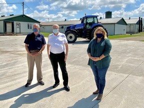 Ernie Hardeman, Minister of Agriculture, Food and Rural Affairs (middle) visited the Monoway Farms, south of Belgrave, on Friday to announce that the provincial government has expanded the Risk Management Plan by $50 million, bringing the total to $150 million annually. With him are MPP Randy Pettapiece, Parliamentary Assistant to Minister of Agriculture, Food and Rural Affairs, and Huron Bruce MPP Lisa Thompson. Submitted