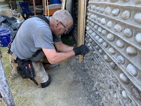 Gord Cowan, of Brantford, works on a restoration project on a wall at 165 Grand River Street North. Cowan is restoring a cobblestone wall for Jean Sonmor and Regan Devine, the owners of the heritage home.