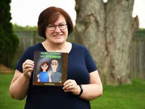 Paula Morrison, who wrote a pandemic-based children's book called Grammy and Granmpy Were Grounded!, holds up the book outside of her Chatham home July 21, 2020. (Tom Morrison/Chatham This Week)