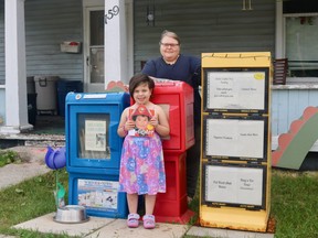 Ruth Kobrin, with the help of six-year-old daughter Leili-Rose, runs a free pantry, library, and toy box out of her front yard on Queen Street in Delhi. (ASHLEY TAYLOR)