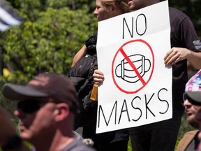 An anti-mask protestor holds up a sign in front of the Ohio Statehouse during a right-wing protest, entitled Stand For America Against Terrorists and Tyrants, last week in Columbus, Ohio. JEFF DEAN/AFP via Getty Images.