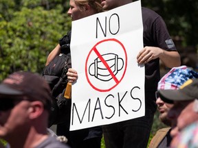 An anti-mask protestor holds up a sign in front of the Ohio Statehouse during a right-wing protest, entitled Stand For America Against Terrorists and Tyrants, last week in Columbus, Ohio. JEFF DEAN/AFP via Getty Images.