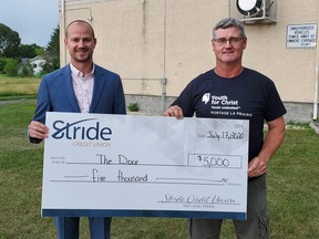 Ryan Hildebrandt, from Stride Credit Union  and Art Schroeder from the Door pose with the donation. (supplied photo)