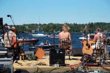 People watch(from left) Mike Procyshyn, Merel van der Wielen and Reilly Scott perform from their boats at the 12th 'Modified Maybe Annual' Coney Island Music Festival on Sunday, July 26. People came in their boats to adhere to the public health restrictions amid the COVID-19 pandemic.