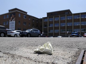 A discarded mask lies in the parking lot of Belleville General Hospital. Authorities say masks and other safety precautions are still needed amid Ontario's reopening, and an expected wave of COVID-19 could again heighten restrictions.