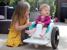 Harper Hanki sits outside with sister Kinsley, 3, during the Friday evening at their home in Parkland County. The GoFundMe for Hanki can be found by searching for "My Hero Harper - Spinal Muscular Atrophy Type 1" on the site.