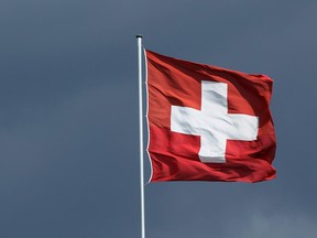 BERLIN - AUGUST 25:  A Swiss flag flies under dark clouds over the Swiss embassy on August 25, 2010 in Berlin, Germany.