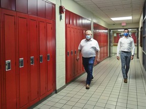 Ontario Premier Doug Ford, left, and Education Minister Stephen Lecce walk the hallway before making an announcement regarding the governments plan for a safe reopening of schools in the fall due to the COVID-19 pandemic at Father Leo J Austin Catholic Secondary School in Whitby, Ont., on Thursday, July 30, 2020. (THE CANADIAN PRESS/Nathan Denette)