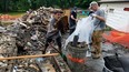 Damian Misa, of Rick's Construction, left, and Bruce-Grey-Owen Sound MP Alex Ruff, right, help clean up the debris Wednesday in Owen Sound from a house fire at 848 8th Ave. E. (Scott Dunn/The Sun Times/Postmedia Network)