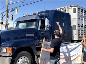 Ag supporters (with banner) celebrate after police remove activist Sabrina Desgagnes and other animal rights activists from in front of a transport entering the Sofina Fearman's Pork Ltd. processing plant (Diana Martin, Ontario Farmer)