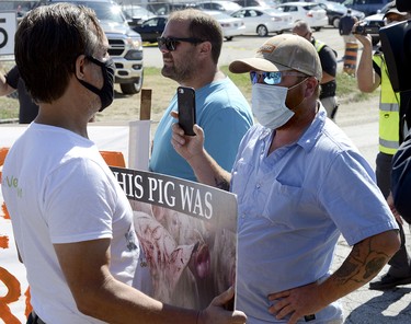An animal rights activist, left, and ag-supporter, right, have a quietly intense dialogue about their opposing views - stopping the processing of animals for consumption and the rights of drivers to be safe as well as the right for people to decide what they want to eat. The ag-supports have reiterated they are not against the protests, just the unsafe nature in which they are being conducted. (Diana Martin, Ontario Farmer)