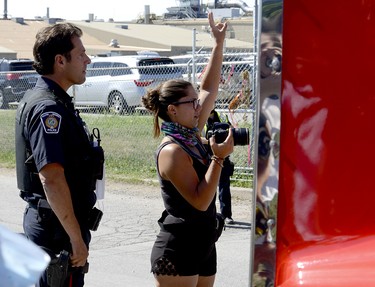 Halton Regional police, left, watch as activist Sabrina Desgagnes, right, stands in the blind spot of a transport attempting to enter the Sofina Fearman's Pork Ltd. processing plant (Diana Martin, Ontario Farmer)