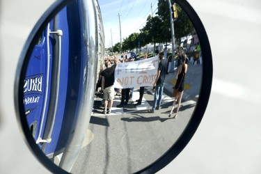 Halton Regional Police Service members move in as ag supporters (with banner) and animal activists share some heated words at the side of a truck in the left lane of traffic as it stops before entering the Sofina Fearman's Pork Ltd. processing plant in Burlington (Diana Martin, Ontario Farmer)