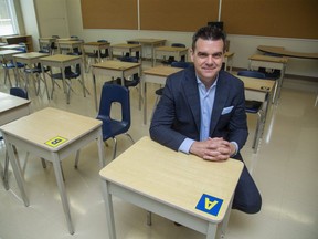 Mark Fisher, Director of Education and CEO of Thames Valley District School Board sits at a classroom desk marked with the letter "A" at Eagle Heights Public School. One of the options being examined is splitting classes into two cohorts and having them attend school on different days. Students in "A" cohort would sit a desks marked with an "A" while students in "B" cohort would sit at desks marked with "B" to ensure social distancing. (Derek Ruttan/The London Free Press)