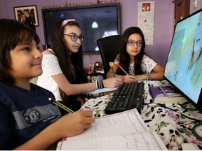 Children continue their school curriculum online via a computer screen at their home in Kuwait City on March 23, 2020.