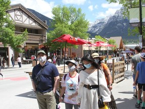 Tourists walk in downtown Main Street in Canmore in the open pedestrian area. Photo Marie Conboy.