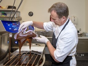 John Spear of Le Chocolatier pours melted chocolate out of a mould to make a chocolate shoe at his shop on Benchlands Trail in Canmore. photo by Pam Doyle/www.pamdoylephoto.com