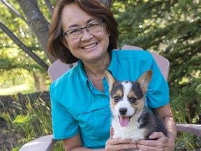 Jenni Evans, Cruise and Travel Advisor with JennsJourneys.ca/Vision Travel, holds her corgi puppy Tobi at her home in Canmore. photo by Pam Doyle/www.pamdoylephoto.com
