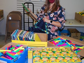 Sarah Raynsford, co-ordinator of the United Way of Bruce Grey's annual backpack program, stuffs school bags with supplies Tuesday at Heritage Place Shopping Centre in Owen Sound. DENIS LANGLOIS