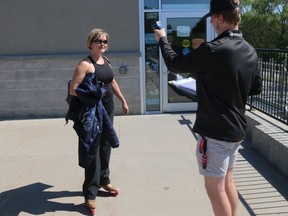 I Can Excelk Skating Academy owner Lisa Conley gets her temperature taken by Soo Greyhound netminder Ethan Taylor prior to a skating session at Rhino Sports & Playland Saturday afternoon. Conley was able to resume giving skating lessons a week ago. BRUCE BELL