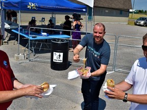 Mayor Mitch Panciuk, Dug Stevenson, Bay of Quinte Marketing Board, and Belleville Chamber of Commerce President Greg Sudds helped launch the first day of the three-day Curbside Culture event at the city fairgrounds by trying some of the international fare on offer by vendors. DEREK BALDWIN