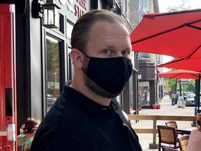 Mark McKay, floor supervisor and bartender at the 1000 Islands Brewing Company on King Street in Brockville, wears a mask while booking customers on a busy Friday afternoon. (RONALD ZAJAC/The Recorder and Times)