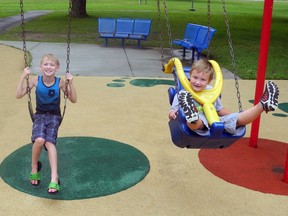 Jayden Evans, 8, and Carsyn Love, 3, enjoy the swings in Hardy Park that were reopened Friday. Wayne Lowrie/Recorder and Times