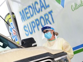 Erin Hill of the Tilbury District Family Health Team works at a mobile drive-thru COVID-19 testing clinic at the Tilbury Memorial Arena parking lot in Tilbury, Ont., on July 10, 2020. (Mark Malone, Postmedia Network)