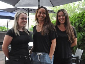 Kalista Coleman, server, left, Dominique Gilgen, owner of Truffles Burger Bar and Deedra Lord, server prepared to greet customers as this year's Ribfest launched with a new format this week  in Cornwall, Ont. Joshua Santos/Cornwall Standard-Freeholder/Postmedia Network