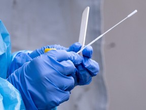 A nurse gets a swab ready at a temporary COVID-19 test clinic in this file photo.