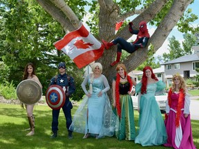 Volunteers dress up as superheroes and princesses for a small parade through Cochrane on Canada Day. Photo by Kelsey Yates