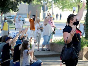 The crowd at the Anti-Racism Against Migrant Workers rally on July 17 took a moment to salute the migrant workers that make sacrifices for Ontario farms. At right is immigration consultant Nancy Thompson. Ashley Taylor photo