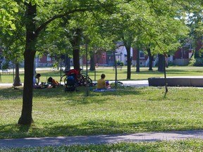 A few people sit in the shade near the splash pad at Victoria Park on Tuesday afternoon. A heat warning has been issued for the Kingston region, with daytime temperatures expected to hit 31 C on Thursday and 32 C on Friday. (Matt Scace/For The Whig-Standard)