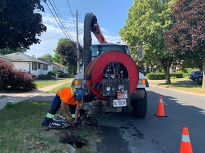 Contractor Daniel Lane does some initial work on a sewer on Kingscourt Avenue on Wednesday in preparation for a relining of about five kilometres of sanitary sewer in the neighbourhood in Kingston. (Elliot Ferguson/The Whig-Standard)
