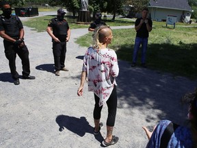 A Belle Park camper confronts city bylaw officers after an eviction notice was issued for homeless people living at the park in Kingston, Ont. on Tuesday, July 28, 2020. 
Elliot Ferguson/The Whig-Standard/Postmedia Network