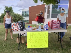 Masked volunteers hand out hygiene kits from Lions Civic Park on Thursday in Kingston, Ont. Supplied photo