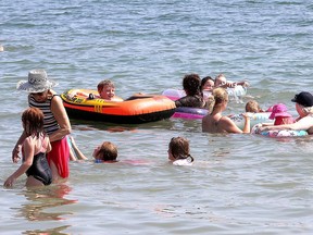A crowd of people swim in the water during 30 C heat at Grass Creek Park beach on Tuesday. (Ian MacAlpine/The Whig-Standard)