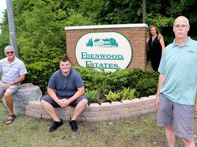 Residents from the Edenwood Estates subdivision concerned with their internet service include Paul Cowx, foreground, and rear, from left, Ron Cumming, Cameren Hogan and Kathryn Bates, seen at their community sign on Battersea Road just north of Kingston Mills Road on Tuesday. (Ian MacAlpine/The Whig-Standard)