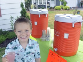 Arik Scheuerman, 6, shows off an ice cold cup of lemonade he was selling at a stand in front of their home on St. George Street in Mitchell July 18, with the majority of proceeds being donated to the Mitchell and Area Food Bank. ANDY BADER/MITCHELL ADVOCATE