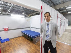 Ian Ball, a critical care doctor for London Health Sciences Centre, stands next to one of the rooms at the LHSC field hospital being constructed at the Western Fair District Agriplex in London on Tuesday, April 7. The 144-bed unit was created to treat patients who are on the mend from COVID-19 but not well enough to go home, said Ball. The unit could have expanded to 500 beds. (Mike Hensen/The London Free Press)