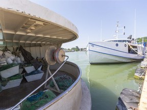 Lake Erie commercial fishing boats lie tied up in the Port Stanley harbour south of London, Ont. on Thursday July 9, 2020. The stern area of the fishing boats is a working area for laying and retrieving the nets as a large pulley and nets and floats sit waiting the next trip. (Mike Hensen/The London Free Press)