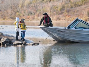 A fish and wildlife officer chats with some children. Officers have been patrolling Alberta waters to ensure people are complying with the rules and being safe.